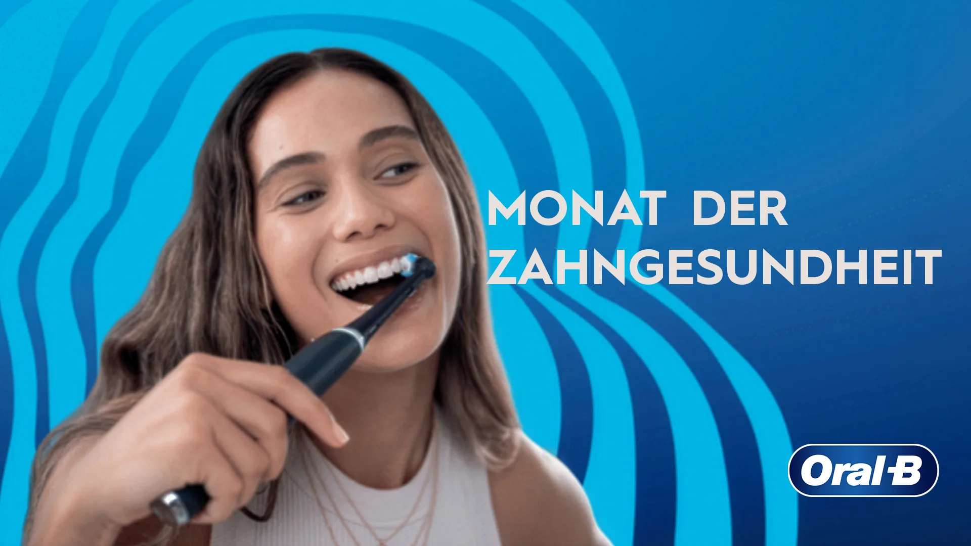 Dunkelhaarige Frau putzt sich mit einer elektrischen Zahnbürste von Oral-B die Zähne. Dies soll zum Tag der Zahngesundheit auf die Bedeutung der Prävention hinweisen.