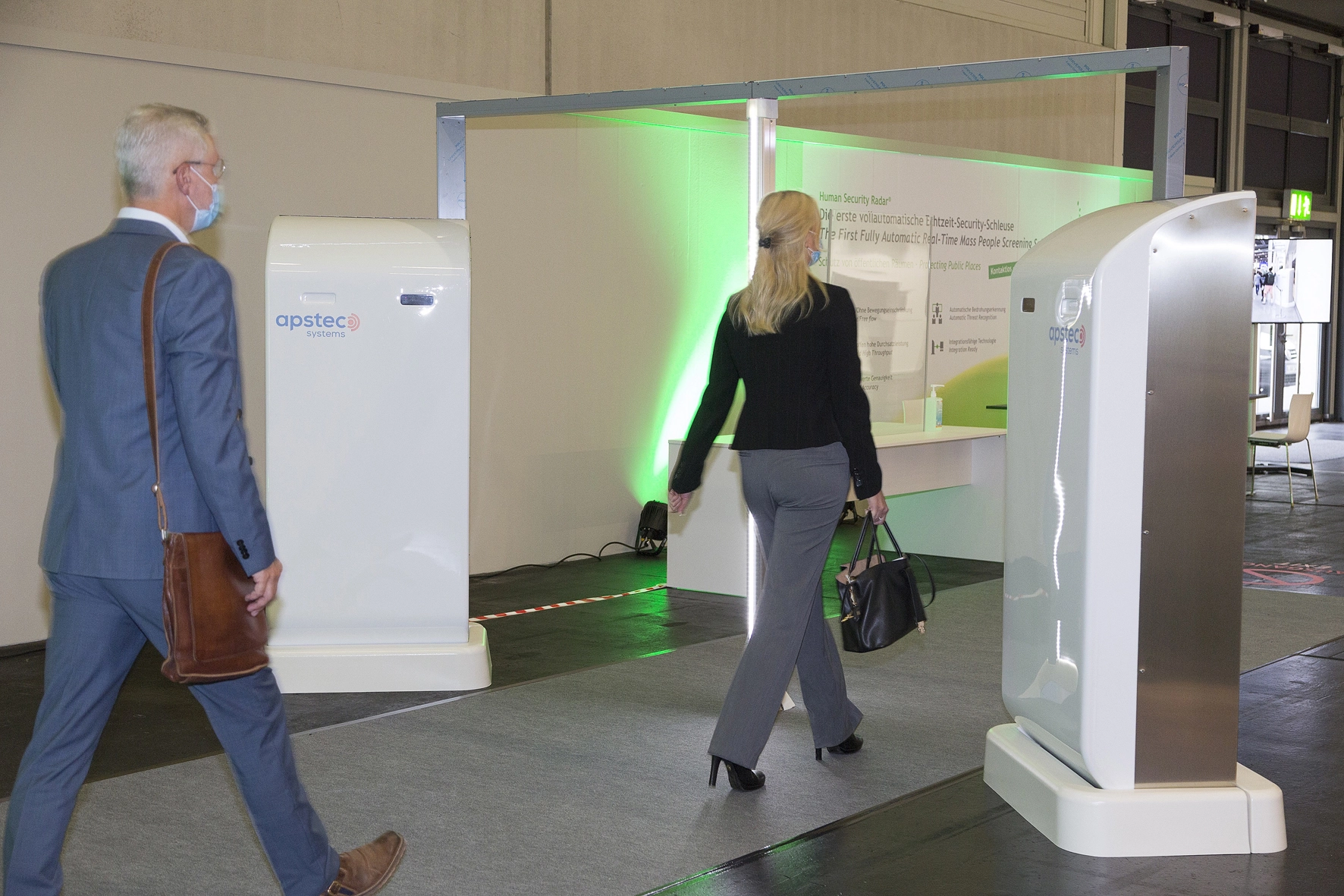 Besucher passieren den Human Security Radar zur kontaktlosen Taschenkontrolle.