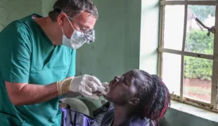 Dr. A. Pathe bei der zahnmedizinischen Untersuchung und Behandlung einer Patientin während eines Mobilen Einsatzes in einer entlegenen , ländlichen Region im Westen Kenias.