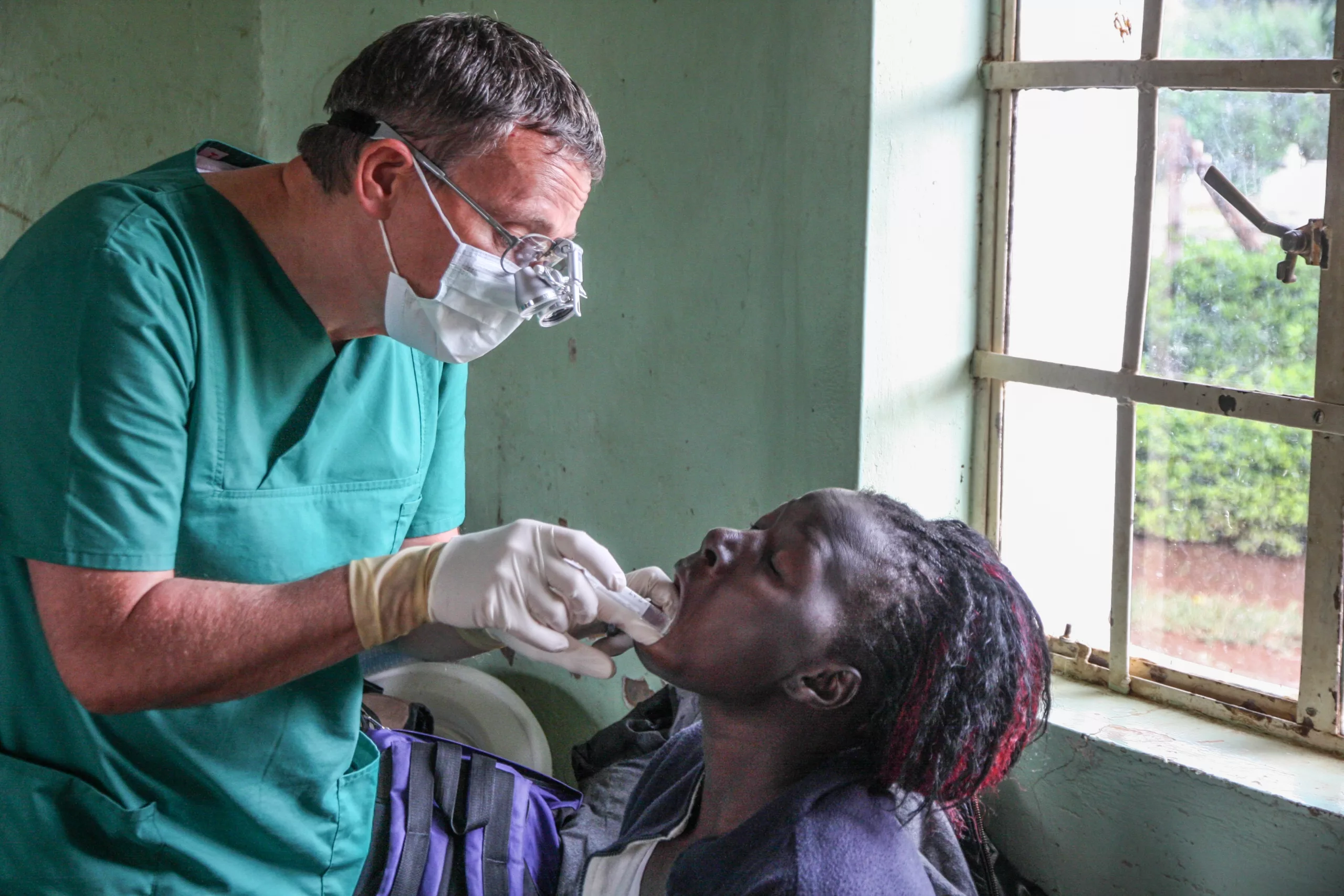 Dr. A. Pathe bei der zahnmedizinischen Untersuchung und Behandlung einer Patientin während eines Mobilen Einsatzes in einer entlegenen , ländlichen Region im Westen Kenias.