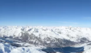 Blick vom Corvatsch auf die Seenlandschaft mit gegenüber liegender Bergkulisse.