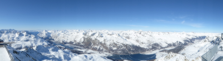 Blick vom Corvatsch auf die Seenlandschaft mit gegenüber liegender Bergkulisse.
