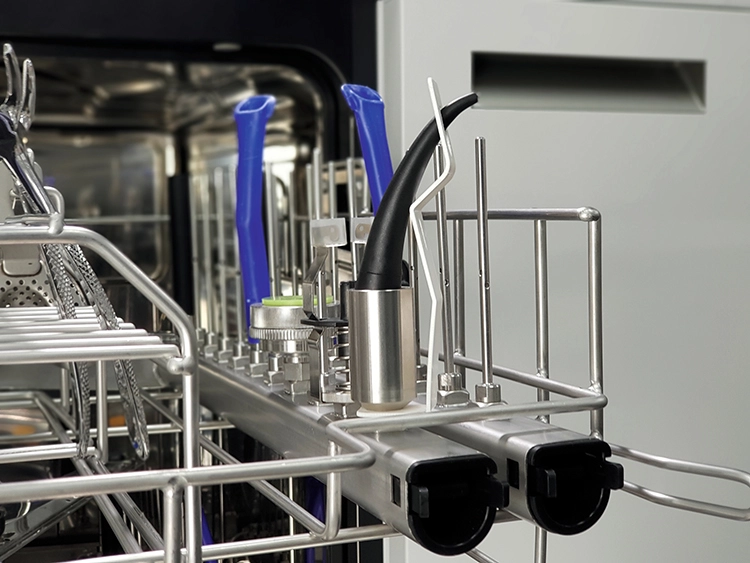 Sicher platziert im Oberkorb: Kanüle einer Multi-Funktionsspritze (vorn), für deren maschinelle Aufbereitung im Thermodesinfektor Miele einen passenden Adapter anbietet.