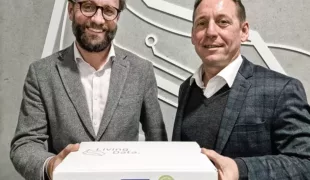 Florian Buchter (l), stellvertretender Vorstand Vertrieb/Marketing bei der REISSWOLF International AG, und Timo Hand, Leitung Marketing und Vertrieb bei enretec, stellen die vorfrankierte REISSWOLF Dokumenten Box zum Sammeln von Papierunterlagen vor.