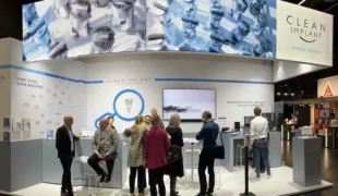 IDS Messebesucher auf der Suche nach Antworten am Stand der CleanImplant Foundation.