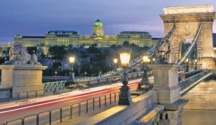 Die Kettenbrücke in Ungarns Hauptstadt Budapest überspannt die Donau, im Hintergrund der Burgpalast.