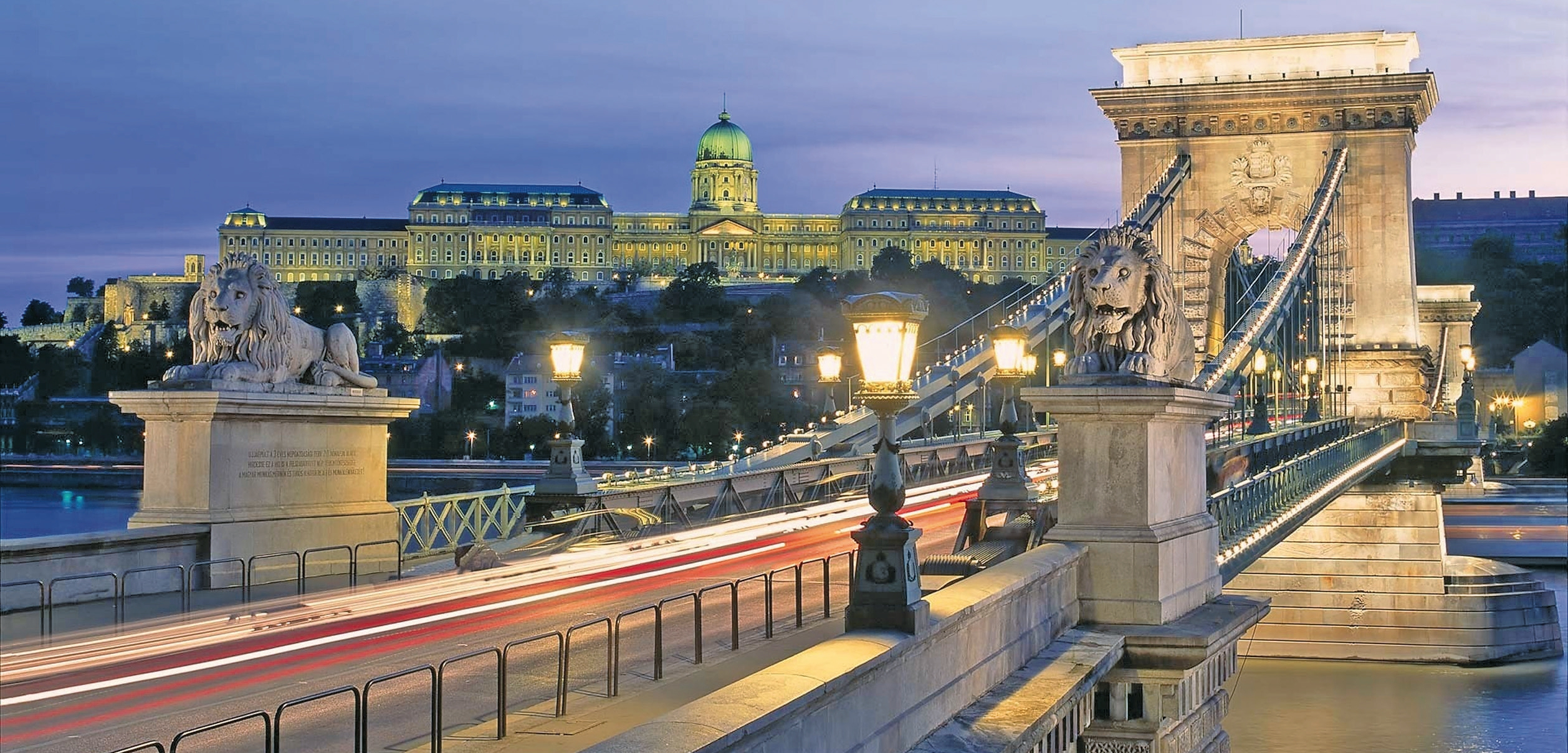 Die Kettenbrücke in Ungarns Hauptstadt Budapest überspannt die Donau, im Hintergrund der Burgpalast.
