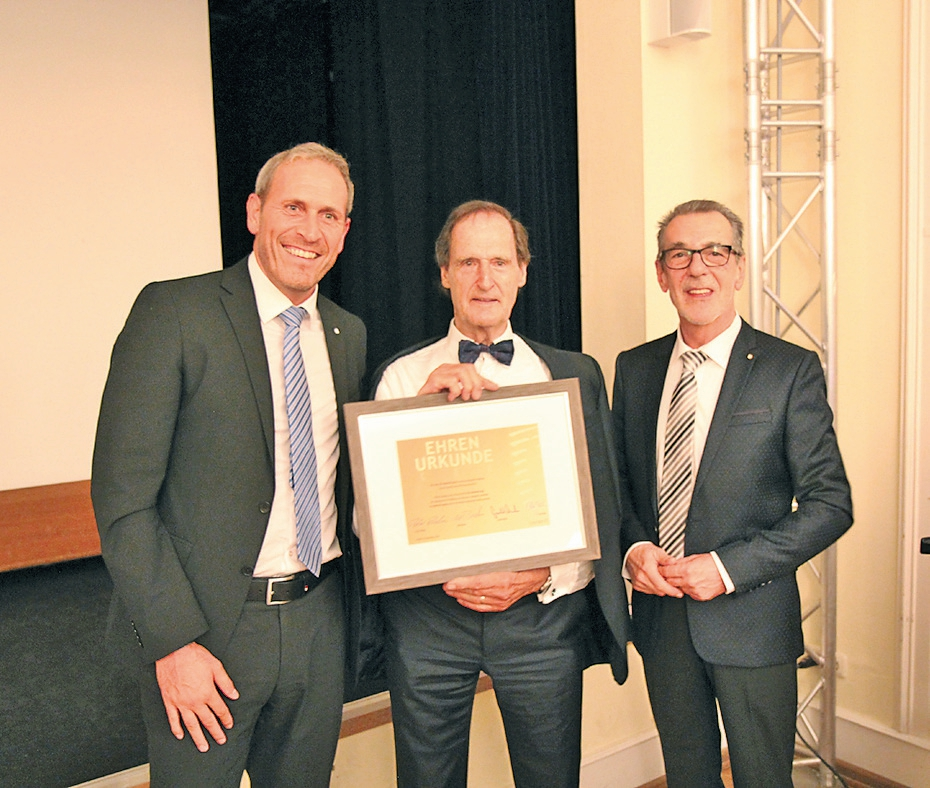 Gerald Micko (links) und Herbert Bibiza von bredent überreichen die Ehrenurkunde an Dr. Manfred Lang.