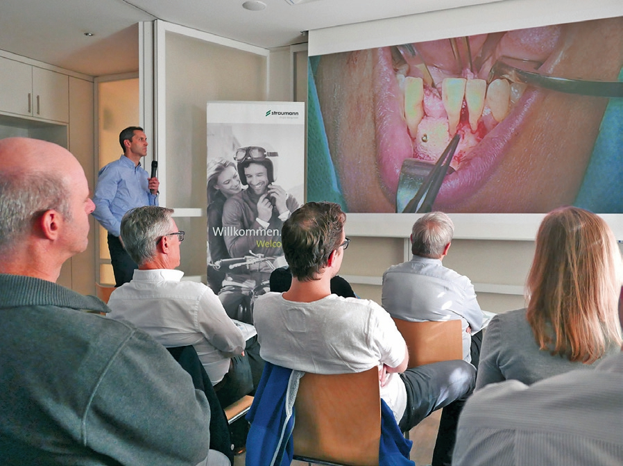 Links im Bild Dr. Michael Back, der Moderator der Live-OP. Auf der Leinwand zu sehen, der mit einer Ostheosyntheseschraube befestigte Knochenblock.