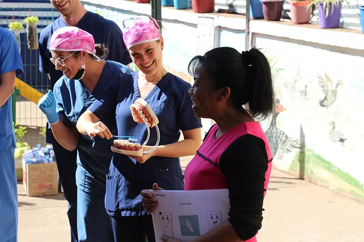 Abb. 4: Die Schulleiterin der ONG Manda zusammen mit dem Planet-Action Team bei der Zahnputzdemonstration.