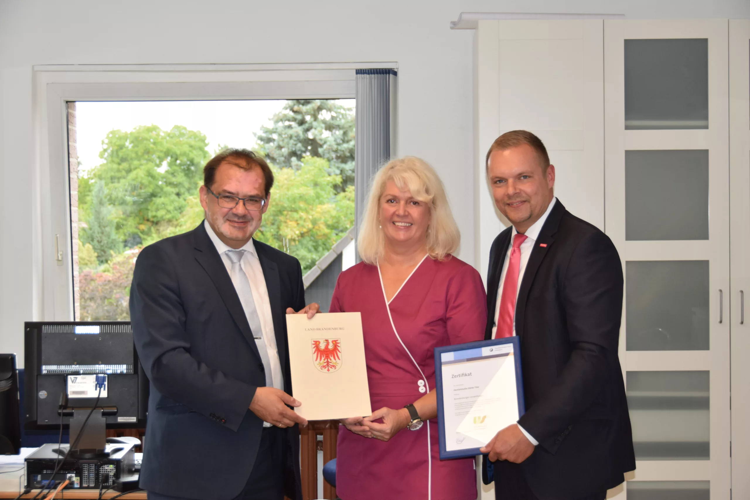 Abb. 1: Übergabe des Umweltsiegels an Dörte Thie; links: Jörg Vogelsänger (damaliger Brandenburger Umweltminister), rechts: Robert Wüst (Präsident Handwerkskammer Potsdam).