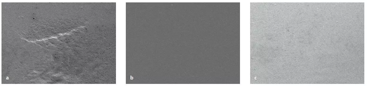 Abb. 4a–c: Schmelzoberfläche nach 5 Sekunden AIRFLOW® mit unterschiedlichen Pulvern (links: Kalziumkarbonat; Mitte: Erythritol; rechts: Natriumbikarbonat 65 ?m)
(REM-Aufnahmen x2.000).