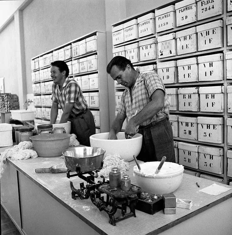 Arbeiter in den 1950er-Jahren beim Zusammen-mischen verschiedenen Rohstoffe zu einer Masse für die Kunstzahnproduktion.