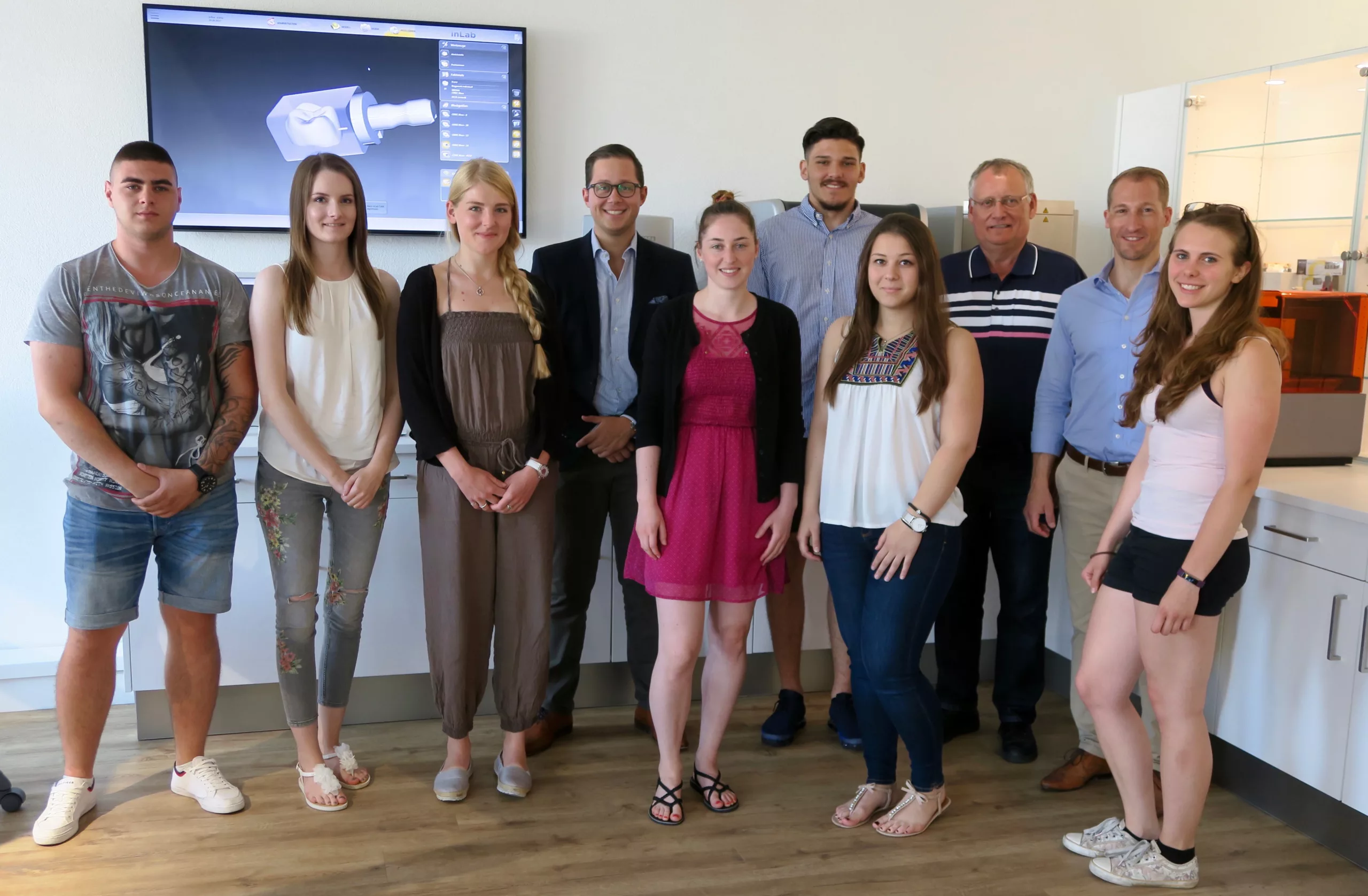 Die Lehrlinge gemeinsam mit Bernhard Breunig (3. v. r.), Andy Vetterli, Sales Manager CAD/CAM & Imaging Systems Switzerland bei Dentsply Sirona (2. v. r.), und Max Mattes, Junior Sales Specialist CAD/CAM Switzerland bei Dentsply Sirona (7. v. r.).