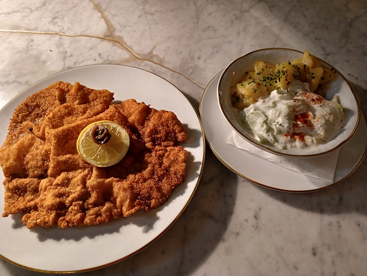 Das echte Wiener Schnitzel mit traditioneller Beilage im Meissl & Schadn serviert.