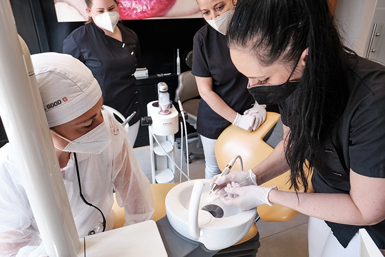 Vor Behandlung der eigenen Patienten üben die Kursteilnehmer mit Trainerin Adina Mauder an den Training-Tools. In diesem Fall wird ein speziell beschichtetes Reagenzglas mit einem piezokeramischen Scaler PIEZON® PS instrumentiert.