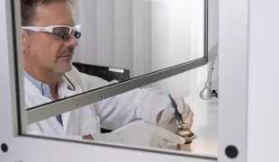Dr. Dirk U. Duddeck montiert ein
Implantatmuster im Reinraum auf den
Probenhalter des Rasterelektronenmikroskops.