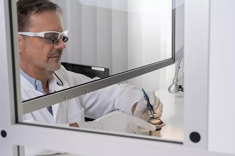 Dr. Dirk U. Duddeck montiert ein
Implantatmuster im Reinraum auf den
Probenhalter des Rasterelektronenmikroskops.