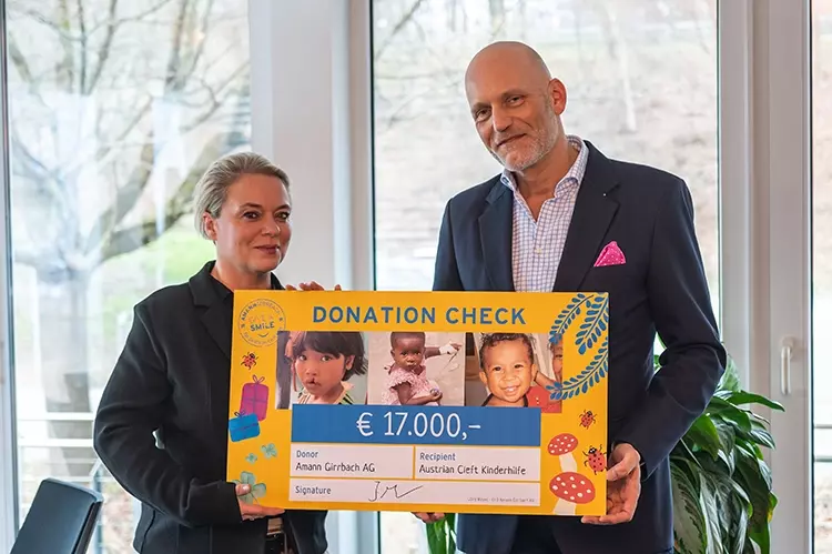 Amann Girrbach CFO Jörg Mayer und die Repräsentantin der Austrian Cleft Kinder-hilfe, Stephanie Günther, bei der Scheckübergabe.