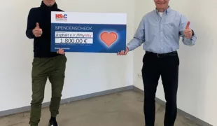 Detlev Fellmann, Gebietsverkaufsleiter NRW bei Henry Schein Dental Deutschland GmbH und Hubert Ostendorf vom Straßenmagazin fiftyfifty bei der Scheckübergabe.