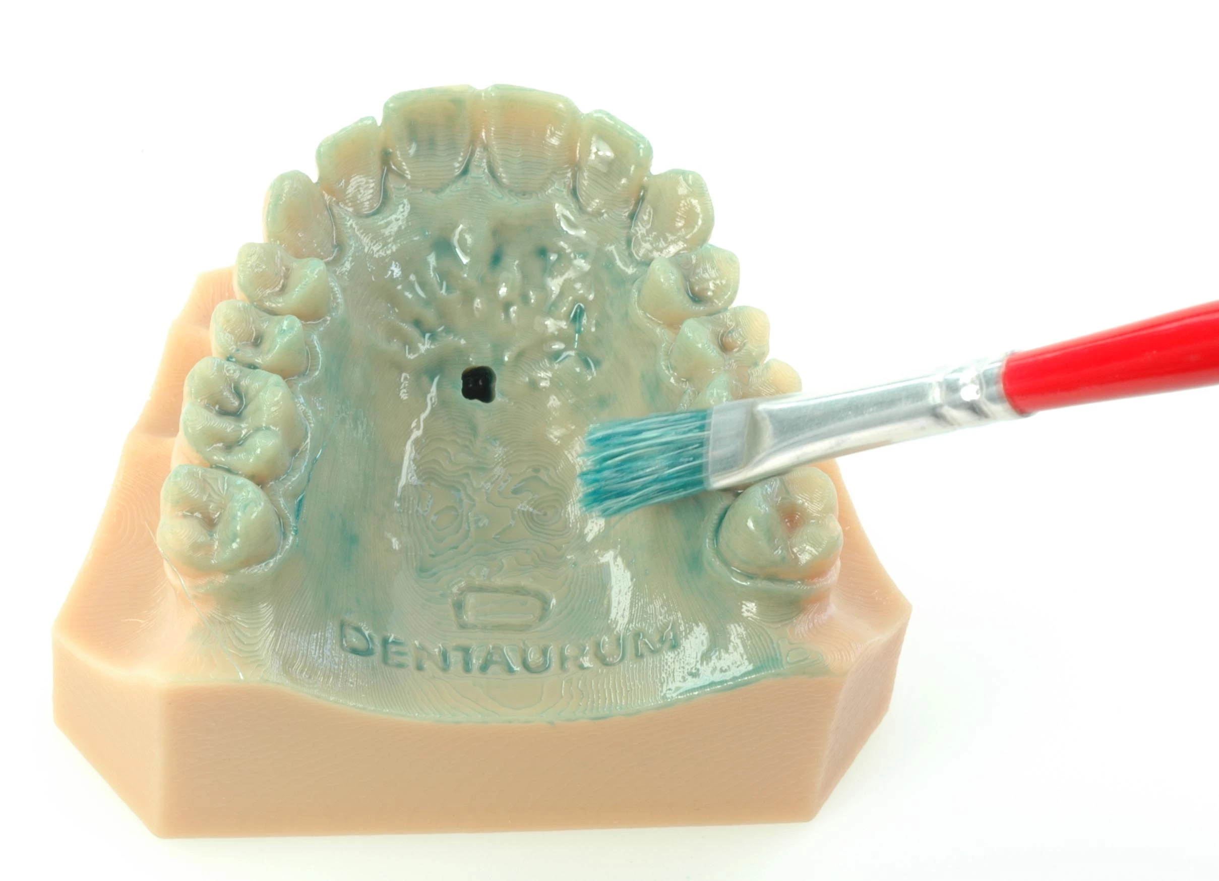 Abb. 1: Auftragen einer Schicht des 3D Isoliermittels auf ein Kunststoffmodell mit Bohrung für die Aufnahme des Dehnschraubenhalters.