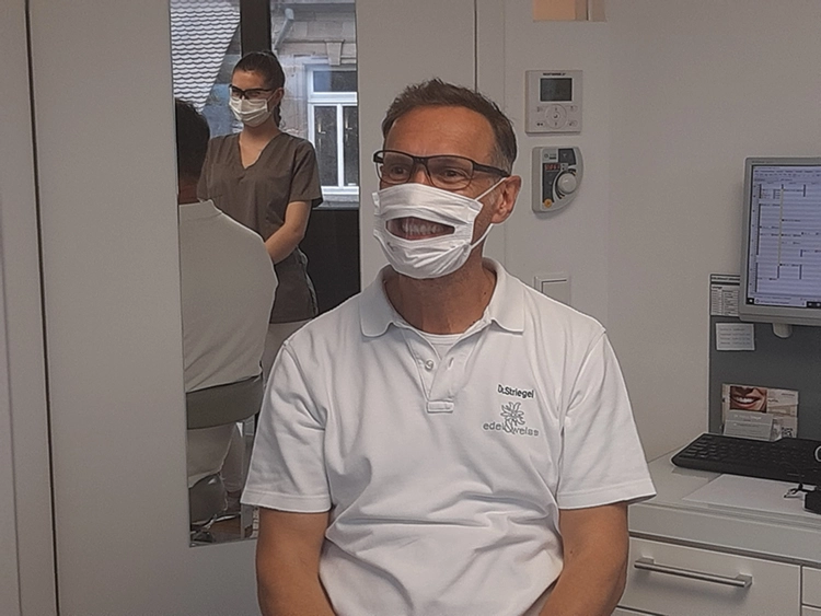 Dr. Striegel, Nürnberg, mit einer für hörbehinderte Patienten geeigneten Maske.