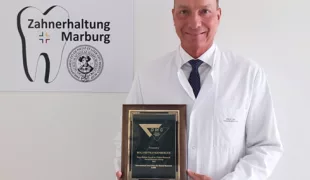 Prof. Dr. Roland Frankenberger zeigt stolz die Urkunde zur Auszeichnung mit dem Ryge-Mahler-Award.