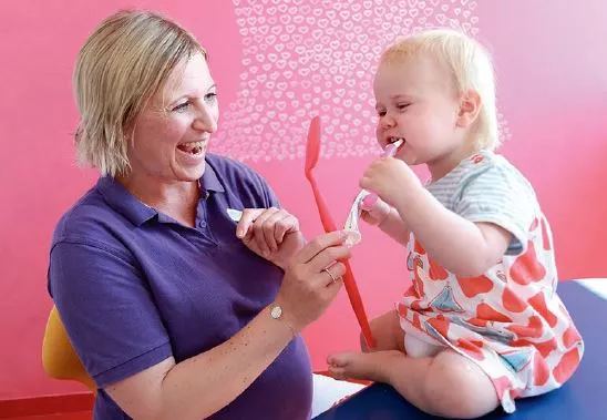Abb. 3: Hier darf eine kleine Patientin ihre eigenen Erfahrungen beim ersten Besuch in einer Kinderzahnarztpraxis machen.