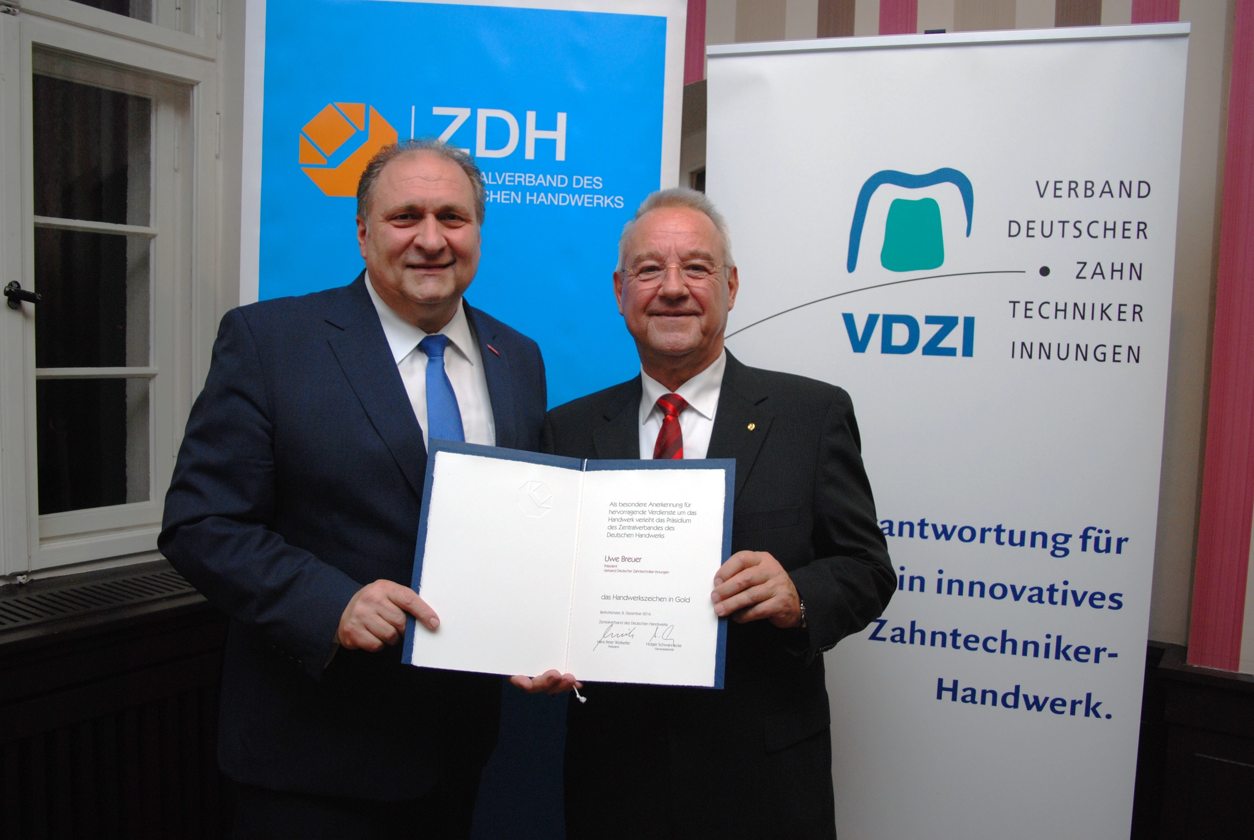 Hans Peter Wollseifer, Präsident des Zentralverbands des Handwerks (links), übergibt Uwe Breuer das Handwerkszeichen in Gold.