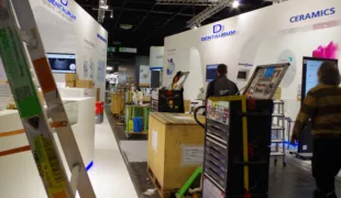 Die IDS im Aufbau – manche Last-Minute-Geschichte verbirgt sich unter den aufgestellten Leitern, den Mülltonnen und den Bergen an Verpackungsmaterial.