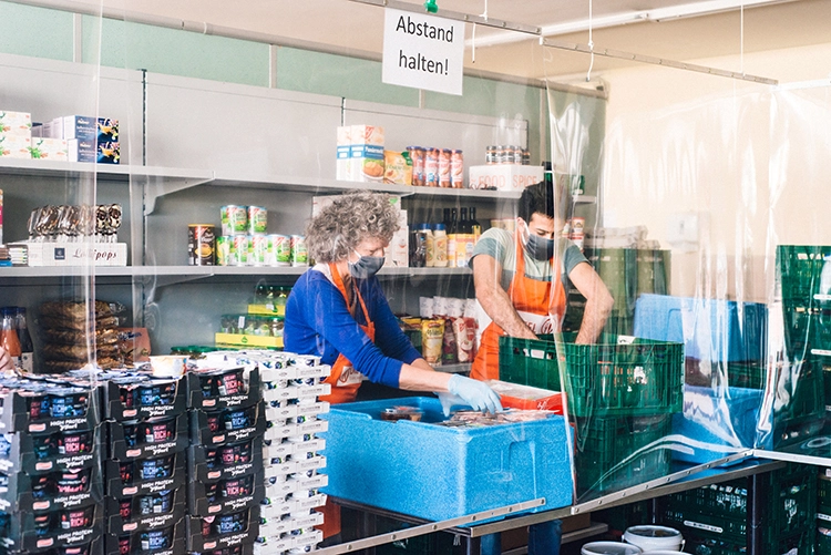 Lebensmittelausgabe hinter Schutzfolie: 2020 stehen die Tafeln vor besonderen Herausforderungen.
