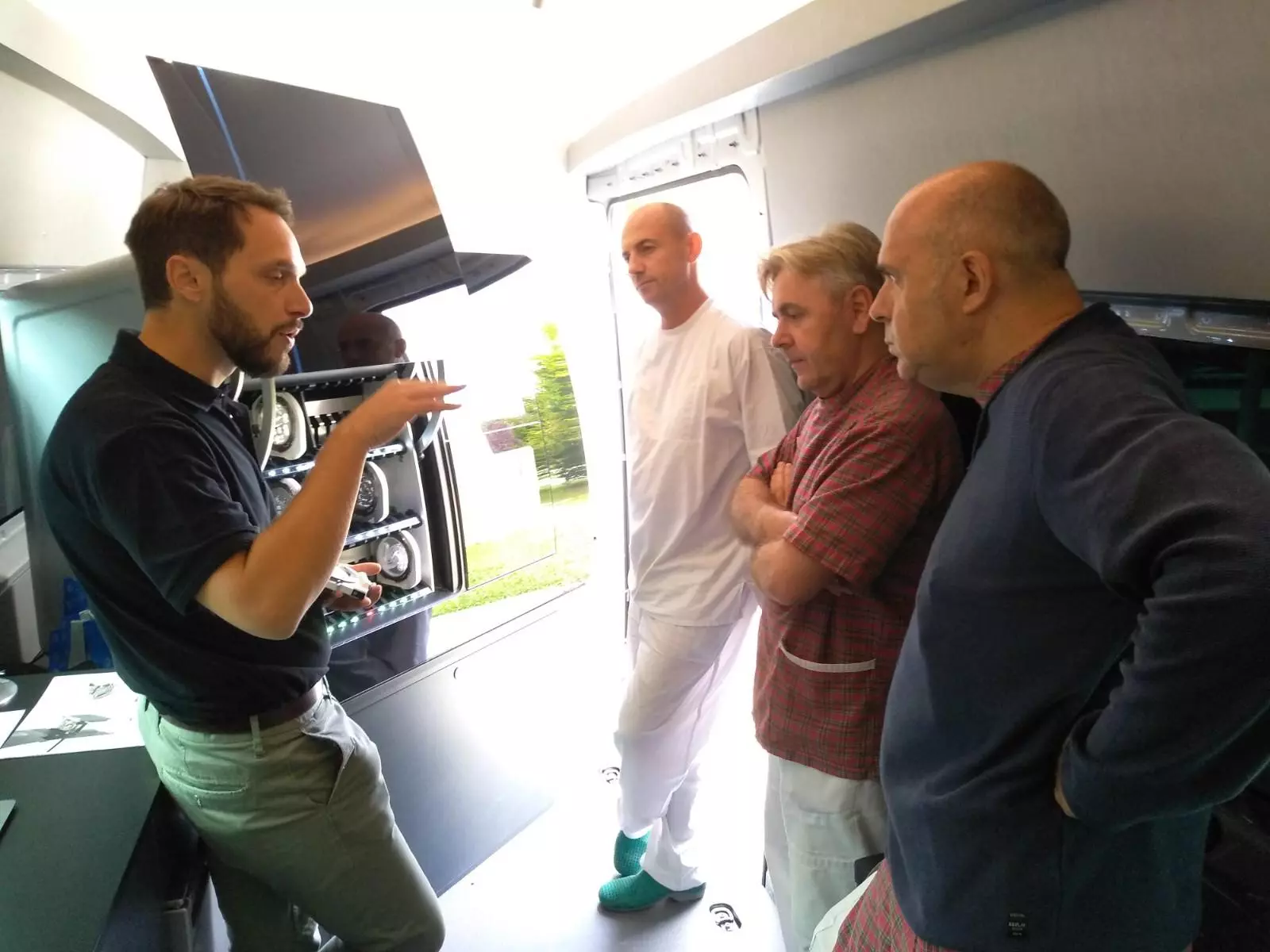 Ein Experte von Amann Girrbach präsentiert Zahntechnikern die neue Ceramill Matik vor den Türen ihres Labors.