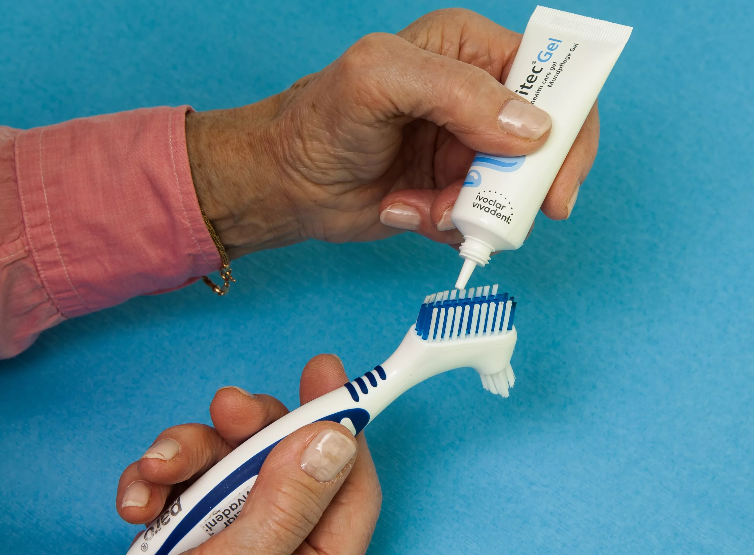 Abb. 1: Prothesenbürste und chlorhexidinhaltiges Mundpflege-Gel zum Reinigen von Zahnersatz.