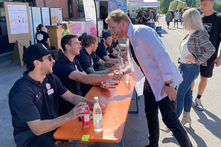 Nico Heinrich übergibt den Sportmundschutz von Peter Holmgren an Nick Pageau, Kapitän des Eishockey-Teams Landshut.