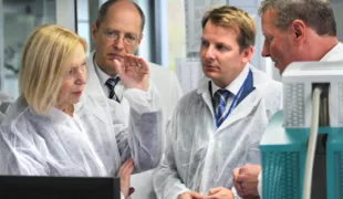 Prof. Dr. Johanna Wanka (Bundesministerin für Bildung und Forschung) mit Manfred Thomas Plaumann (Mitglied der Geschäftsleitung, VOCO), Thiemo Röhler (Landtagsabgeordneter, CDU) und Prof. Dr. Reinhard Maletz in der Abteilung Forschung und Entwicklung.