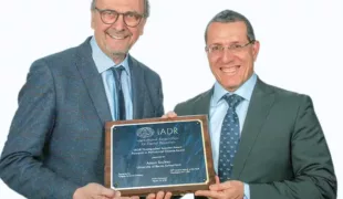 Prof. Dr. Dr. h.c. (mult.) Anton Sculean (rechts) nimmt den von Prof. Dr. Daniel Buser überreichten „Nobelpreis der Zahnmedizin“ gerne entgegen.