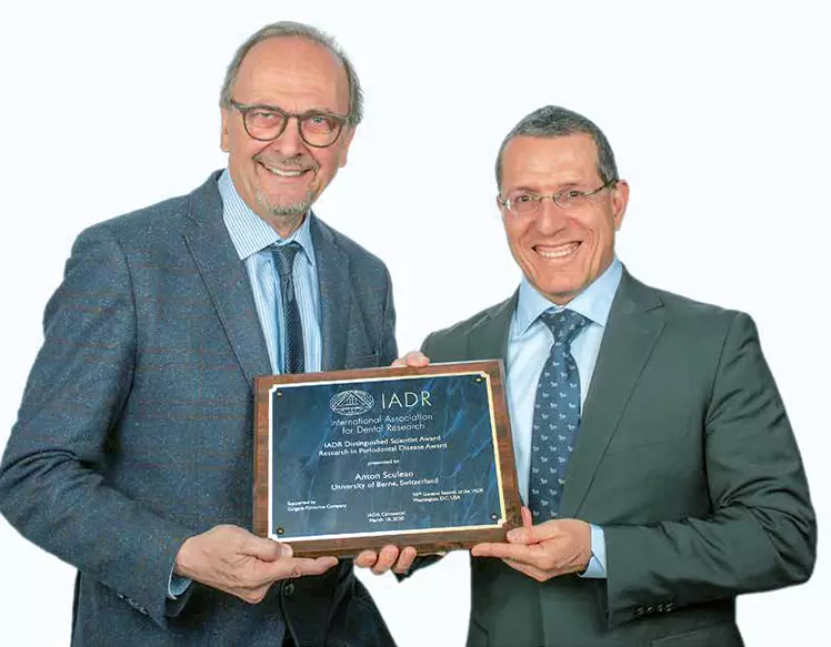 Prof. Dr. Dr. h.c. (mult.) Anton Sculean (rechts) nimmt den von Prof. Dr. Daniel Buser überreichten „Nobelpreis der Zahnmedizin“ gerne entgegen.