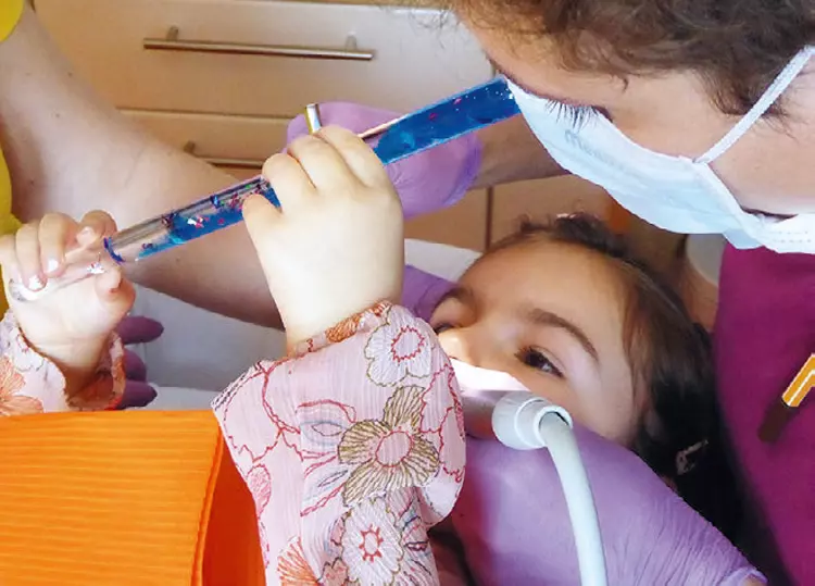 Abb. 3: Diese kleine Patientin befindet sich durch die Fokussierung auf den Zauberstab in einer leichten Trance und ist so von den Vorgängen im Mund völlig abgelenkt.