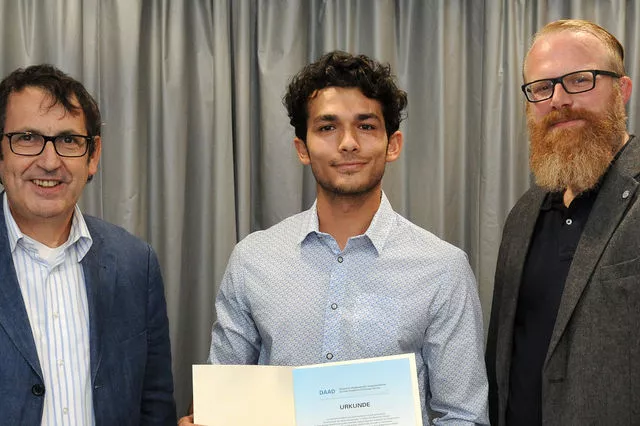 Jim Issa bei der Übergabe der Urkunde mit Prof. Dr. Stefan Zimmer (l.) und UW/H-Vizepräsident Jan Ehlers.