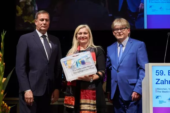 Übergabe des BLZK-Schulungskoffers „Ein Koffer voller Wissen: Mundpflege in der Pflege“ an Melanie Huml. Überreicht wurde der Koffer von Christian Berger (l.) und Dr. Rüdiger Schott (r.).
